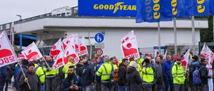 23.11.2023, Brandenburg, Fürstenwalde: Mitarbeiter des Unternehmens der Reifenproduktion von Goodyear demonstrieren nach einer Betriebsversammlung vor dem Werk mit Fahnen der Industriegewerkschaft Bergbau, Chemie, Energie (IG BCE). Nach der Ankündigung des Konzerns, am Standort Fürstenwalde 750 Arbeitsplätze abzubauen, hatte der Goodyear-Betriebsrat während der Versammlung zu den Unterhemens-Plänen Stellung bezogen. Foto: Soeren Stache/dpa +++ dpa-Bildfunk +++