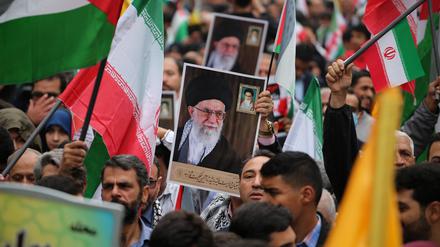 Demonstranten im Iran halten ein Porträt des geistlichen Führers Ali Chamenei hoch.