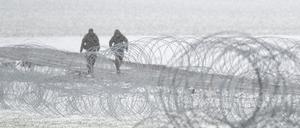 Soldaten des polnischen Militärs patrouillieren hinter Stacheldraht nahe der ukrainischen Grenze.