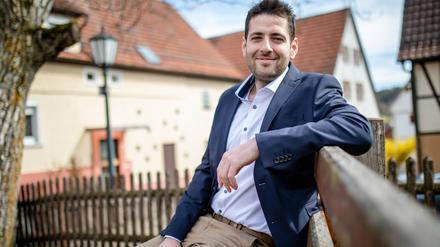 Ryyan Alshebl (Bündnis 90/Die Grünen) sitzt in Ostelsheim auf einer Bank.