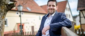 Ryyan Alshebl (Bündnis 90/Die Grünen) sitzt in Ostelsheim auf einer Bank.