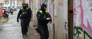 Polizeibeamte gehen bei einer Razzia in Berlin-Friedrichshain zum Eingang eines Gebäudes.