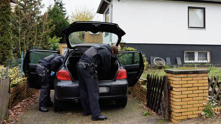 Bei einer Razzia gegen ein Schleusernetzwerk durchsuchen Polizeibeamte im niedersächsischen Garbsen ein Auto in einer Wohnsiedlung.