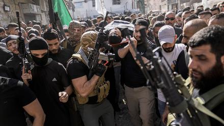 10.11.2023, Palästinensische Gebiete, Dschenin: Palästinenser tragen die Leiche eines Kämpfers, der bei Zusammenstößen während einer israelischen Militäraktion getötet wurde. Bei einem israelischen Militäreinsatz in Dschenin im Westjordanland sind nach palästinensischen Angaben mehrere Menschen getötet worden.