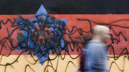 Passanten gehen an dem zerstörten Wandbild des Künstlers Günther Schäfer an der East Side Gallery vorbei. (Symbolbild)