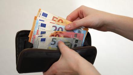 Eine Frau zählt ihre Geldscheine ihrem Portemonnaie. In Zeiten von steigenden Energiekosten müssen viele Bürger den sparen.
