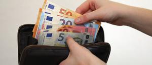 Eine Frau zählt ihre Geldscheine ihrem Portemonnaie. In Zeiten von steigenden Energiekosten müssen viele Bürger den sparen.
