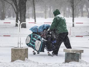 Ein Obdachloser mit einem Einkaufswagen im Berliner Winter.