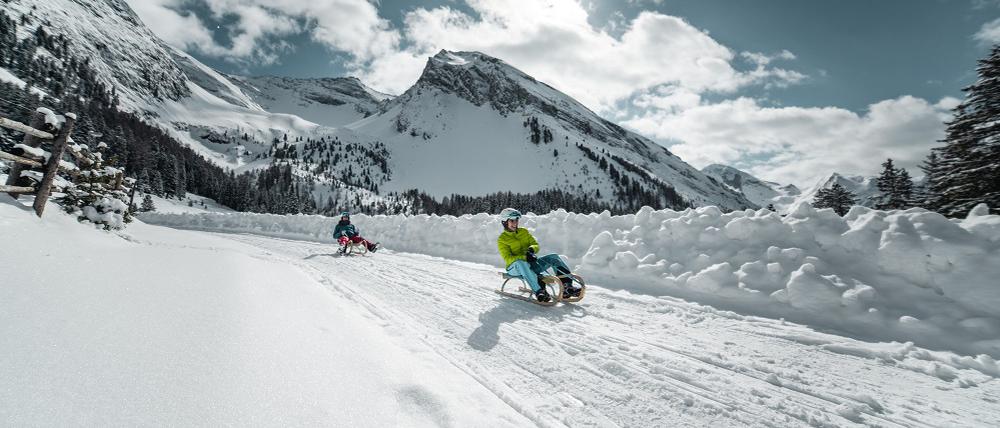Mit dem Schlitten bergab den Hainzenberg in Tirol.