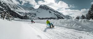 Mit dem Schlitten bergab den Hainzenberg in Tirol.