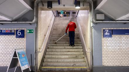 Hart verdientes Geld: Eine Reinigungskraft kehrt in einem Bahnhof einen Treppenaufgang.