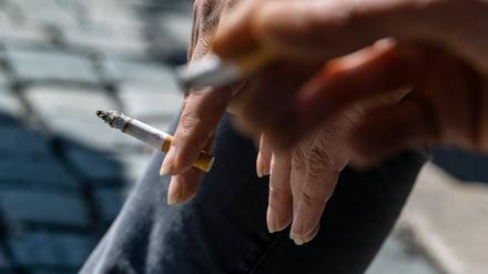 Raucher halten brennende Zigaretten in der Hand.