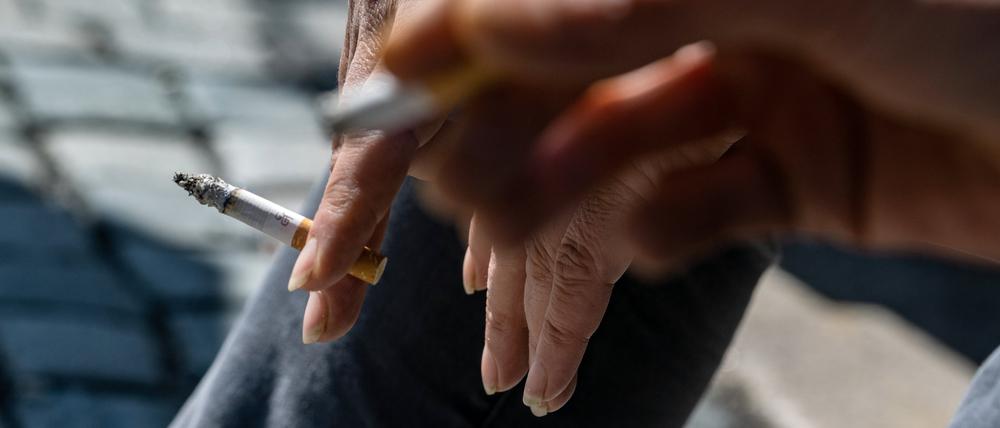 Raucher halten brennende Zigaretten in der Hand.