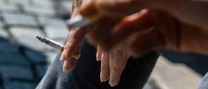 Raucher halten brennende Zigaretten in der Hand.
