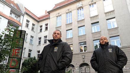 Zwei Security-Männer vor dem Albert-Schweizer-Gymnasium in Neukölln.