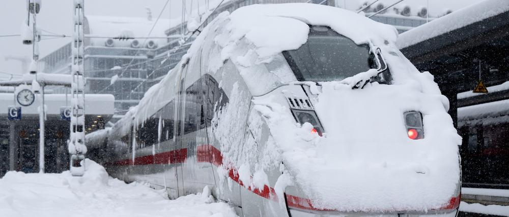  Ein ICE der Deutschen Bahn (DB) steht auf einem verschneiten Gleis am Hauptbahnhof. 