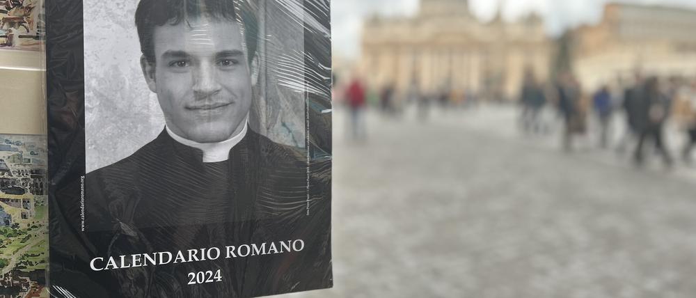 Der „Calendario Romano“ an einem Souvenirstand, im Hintergrund der Petersdom. 
