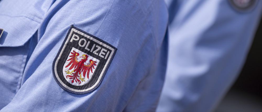 Das Logo der Brandenburger Polizei mit rotem Adler und Schriftzug auf der Uniform eines Polizeibeamten. (Symbolbild)