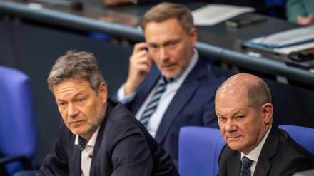 Bundeskanzler Olaf Scholz (SPD, r), verfolgt neben Robert Habeck (Bündnis 90/Die Grünen, l), Bundesminister für Wirtschaft und Klimaschutz, und Christian Lindner (FDP), Bundesminister der Finanzen, die Debatte zur Haushaltslage im Bundestag. Die Ampel-Koalition steht in der Haushaltskrise unter Druck, nun kritisiert auch Brüssel sie scharf.