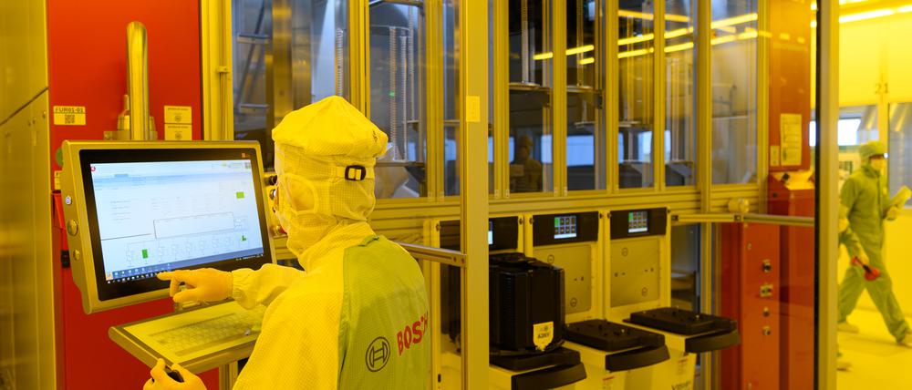 Ein Mitarbeiter steht während eines Presserundgangs in der neuen Halbleiterfabrik von Bosch im Reinraum an einer Maschine für die Bestückung von 300-Millimeter-Wafern. 