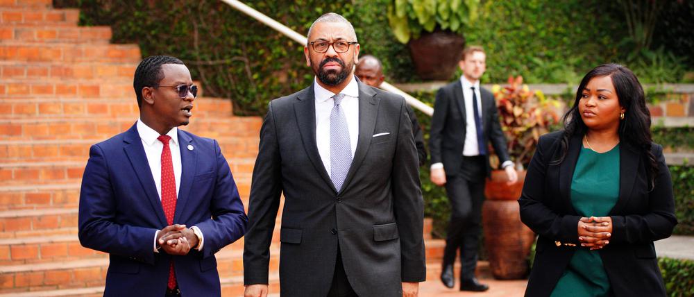 Der britische Innenminister James Cleverly (m.) nach seiner Ankunft in Kigali.