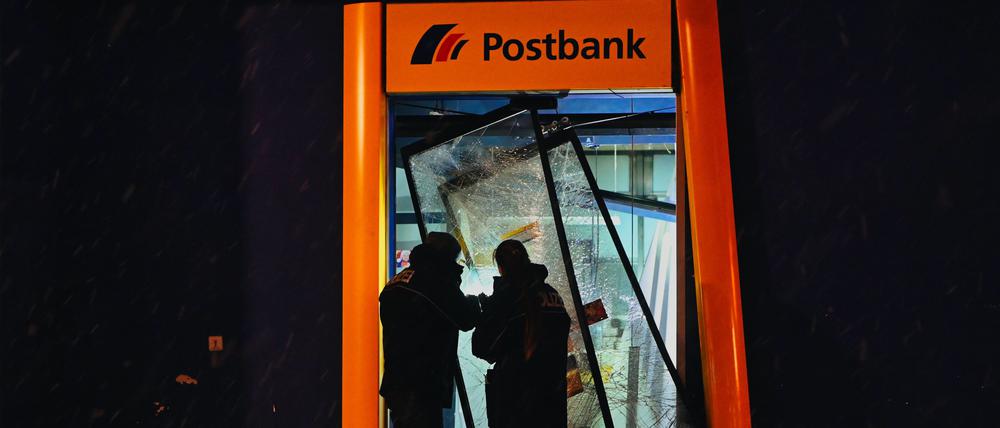 Polizisten stehen im zerstörten Eingangsbereich einer Bank im Märkischen Viertel. 