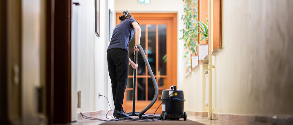 Eine Frau saugt in einem Hotel einen Flur: Rund eine Million Bürgergeld-Bezieher gehen arbeiten und erhalten die Sozialleistung als Aufstockung zu ihrem niedrigen Gehalt.