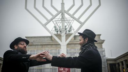 06.12.2023, Berlin: Yehuda Teichtal, orthodoxer Rabbiner, und Rabbi Shmuel Segal tanzen nach der Einweihung des Chanukka-Leuchters am Brandenburger Tor. Ab dem 07. Dezember 2023 beginnt das achttägige jüdische Lichterfest Chanukka. Foto: Kay Nietfeld/dpa +++ dpa-Bildfunk +++