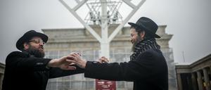 06.12.2023, Berlin: Yehuda Teichtal, orthodoxer Rabbiner, und Rabbi Shmuel Segal tanzen nach der Einweihung des Chanukka-Leuchters am Brandenburger Tor. Ab dem 07. Dezember 2023 beginnt das achttägige jüdische Lichterfest Chanukka. Foto: Kay Nietfeld/dpa +++ dpa-Bildfunk +++