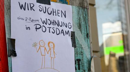 Mit einem Zettel, der im Stadtzentrum angebracht ist und auf dem geschrieben steht „Wir suchen eine 2-Raum-Wohnung in Potsdam“, versucht ein Paar, eine Wohnung zu finden.
