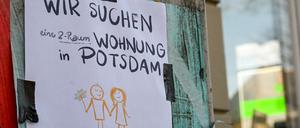 Mit einem Zettel, der im Stadtzentrum angebracht ist und auf dem geschrieben steht „Wir suchen eine 2-Raum-Wohnung in Potsdam“, versucht ein Paar, eine Wohnung zu finden.