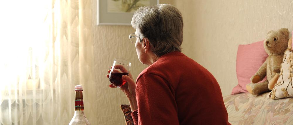 ILLUSTRATION - In der nachgestellten Szene vom 03.04.2012 sitzt eine alte Frau alleine in ihrer Wohnung in Bremen auf dem Sofa und trinkt ein Glas Likör. Der Anteil der Senioren an der Bevölkerung steigt. Doch mit ihren Problemen wie Einsamkeit, Alkoholsucht und Depressionen bleiben sie oft alleine. Foto: Ingo Wagner dpa/lni (Zu dpa-Gespräch "Sucht im Alter kaum zu erkennen" vom 04.04.2012) ++ +++ dpa-Bildfunk +++