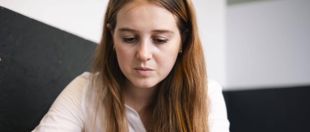 Eine junge Frau schaut auf ihr Smartphone. 