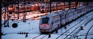 Mehrere ICE der Deutschen Bahn stehen auf verschneiten Abstellgleisen vor dem Hauptbahnhof.