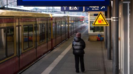 Ein Fahrgast steht auf einem leeren Bahngleis des Potsdamer Hauptbahnhofs, während ein Display über den laufenden Streik informiert. 