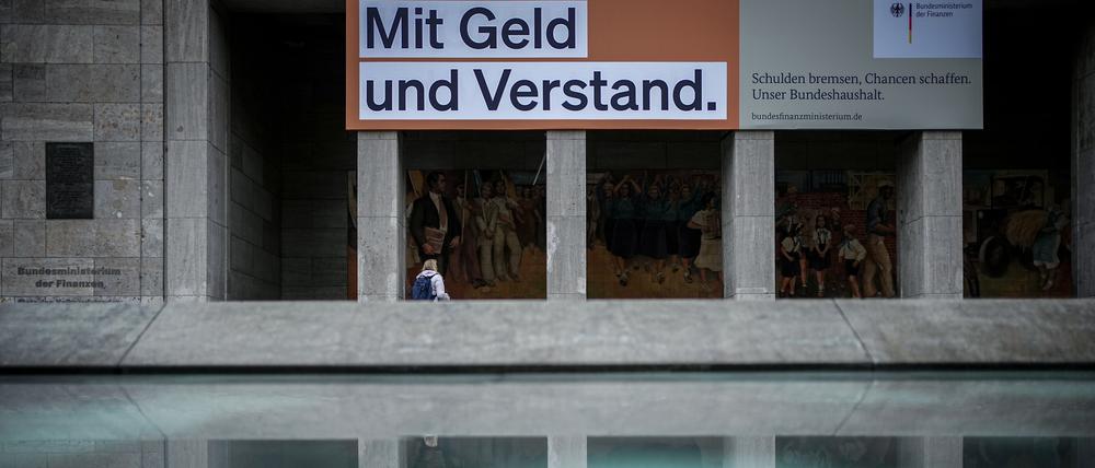 Ein Plakat mit der Aufschrift: „Mit Geld und Verstand. Schulden bremsen, Chancen schaffen. Unser Bundeshaushalt.“ hängt über dem Eingang zum Bundesministerium der Finanzen. Inzwischen ist die Spruchtafel verhüllt. 