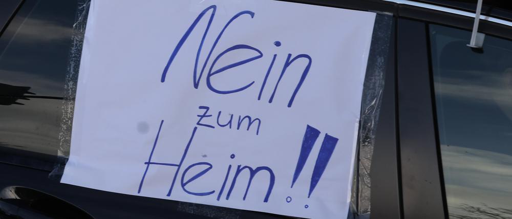 09.12.2023, Thüringen, Gera: Ein Blatt Papier mit der Aufschrift „Nein zum Heim!!“ hängt an einem Auto bei einem Autocorso durch die Innenstadt.