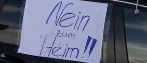 09.12.2023, Thüringen, Gera: Ein Blatt Papier mit der Aufschrift „Nein zum Heim!!“ hängt an einem Auto bei einem Autocorso durch die Innenstadt.