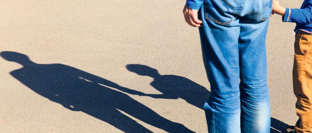 Ein Erwachsener hält die Hand eines Kindes.