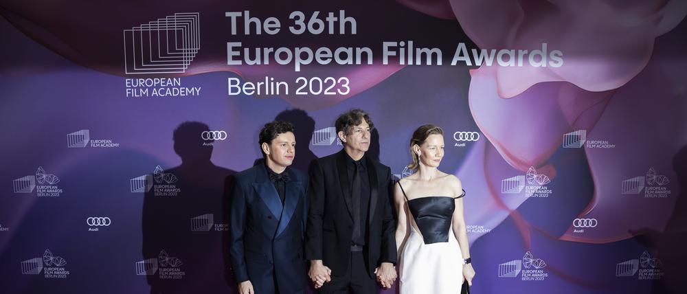 Christian Friedel (l-r), Schauspieler, Jonathan Glazer, Regisseur, und Sandra Hüller, Schauspielerin, kommen zur Verleihung des Europäischen Filmpreises. Die Europäische Filmakademie (EFA) vergibt die Auszeichnungen bei einer Gala in der Arena Berlin.