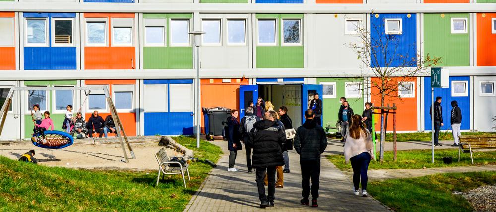Geflüchtete und asylsuchende Menschen halten sich vor einer Notunterkunft in Berlin Hellersdorf-Marzahn auf.