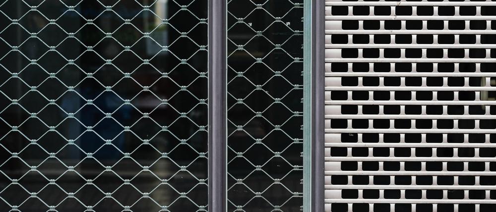 Gitter hängen an der Schaufensterfront eines leeren Geschäfts. Die zahlreichen Krisen machen den Unternehmen in Deutschland zu schaffen.