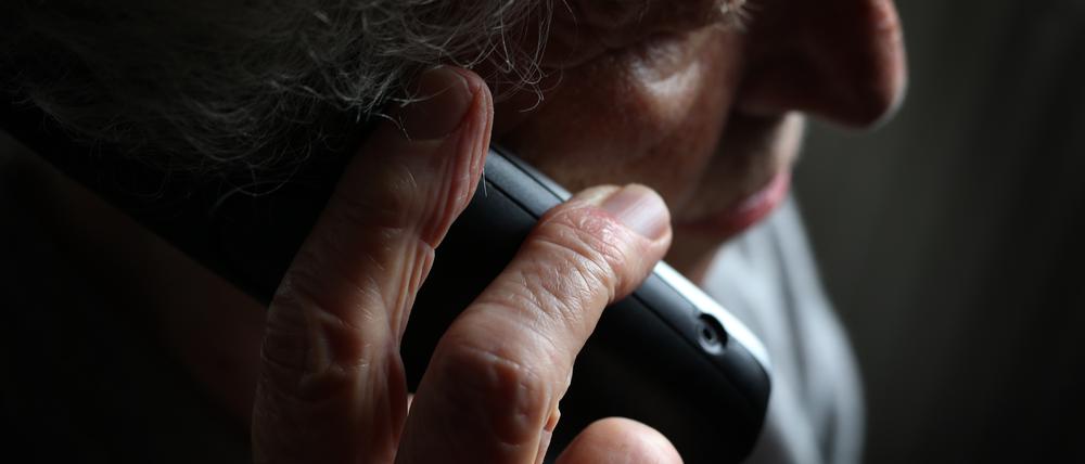 Eine ältere Frau telefoniert mit einem schnurlosen Festnetztelefon. 