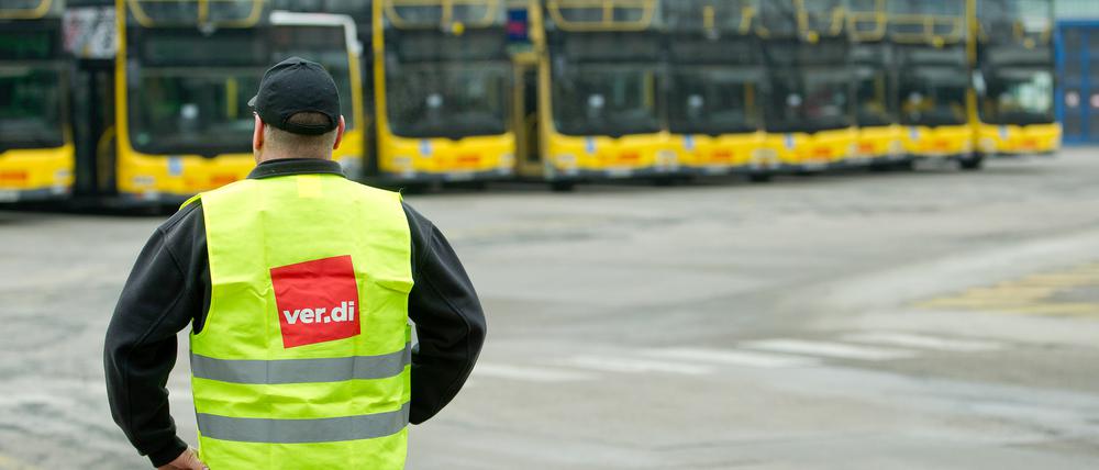 Ein Mann mit Verdi-Weste vor Bussen der BVG (Symbolbild).