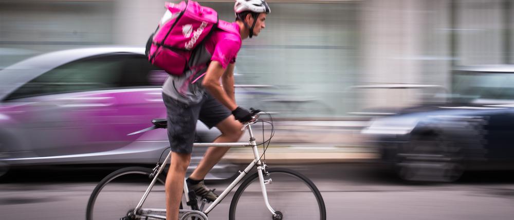 Ein Fahrer des Lieferdienstes „Foodora“, der zu „Delivery Hero“ gehört, fährt durch eine Straße in Berlin. 