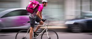 Ein Fahrer des Lieferdienstes „Foodora“, der zu „Delivery Hero“ gehört, fährt durch eine Straße in Berlin. 