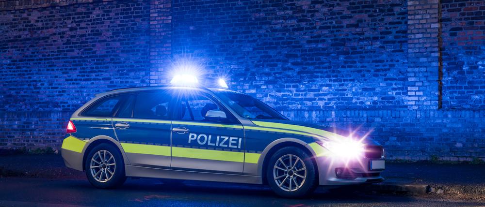 Ein Polizeiauto mit eingeschaltetem Blaulicht bei Nacht. (Symbolbild)