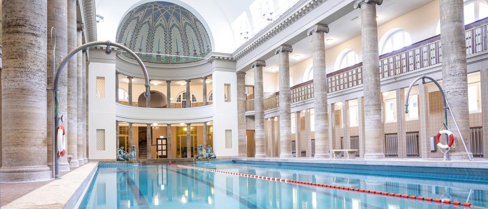 Blick auf menschenleeres blaues Schwimmbecken im Stadtbad Neukölln