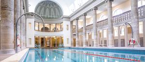 Blick auf menschenleeres blaues Schwimmbecken im Stadtbad Neukölln