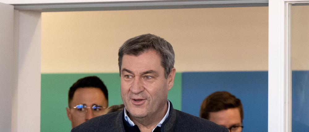 Markus Söder (CSU), Ministerpräsident von Bayern, betritt bei einem Besuch eine Schulklasse. Im Hintergrund hängt ein Kreuz an der Wand. 